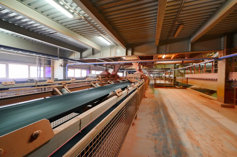 Cinta transportadora para transportar fertilizante en polvo de sal de potasio en el primer plano de la planta de producción. Industria química y minera para la agricultura. Imagen utilizada con fines ilustrativos. Imagen cortesía: Getty Images/Nordroden